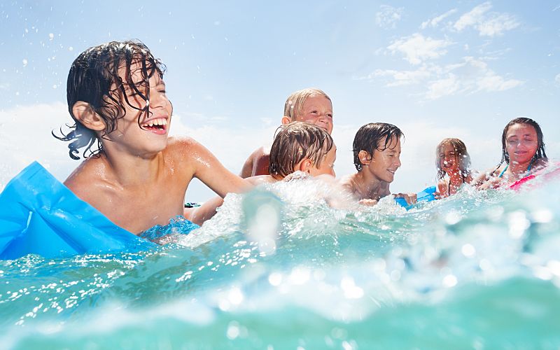 A group of people smiling while swimming in the ocean.