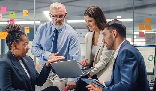 A group of managers sit in an office for a meeting