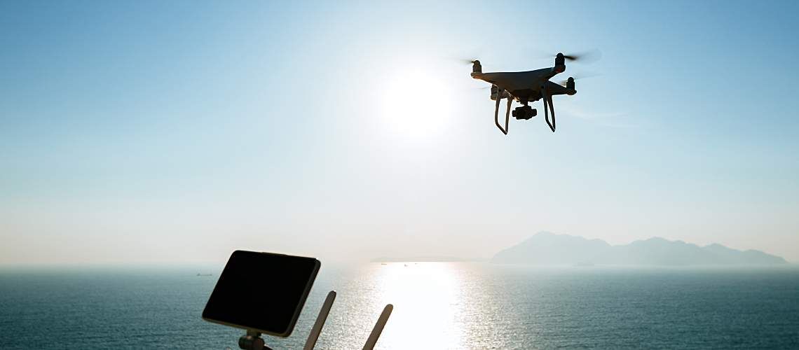 A drone flies over water.