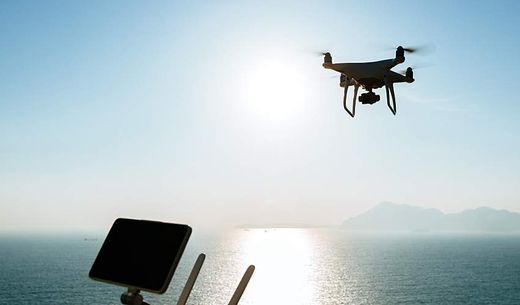 A drone flies over water.