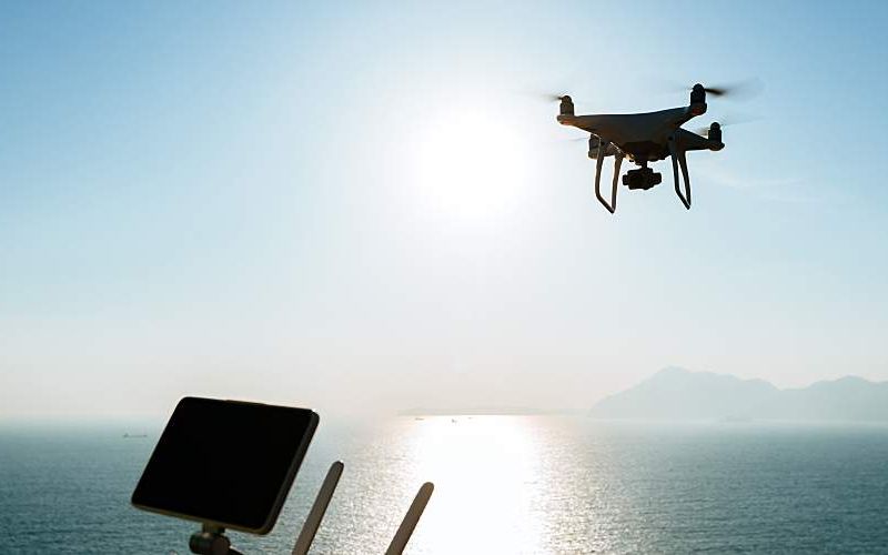 A drone flies over water.