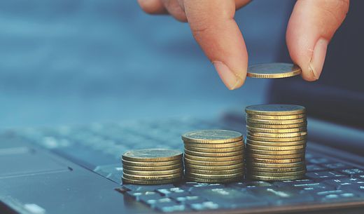 Close-up of a hand counting out coins.