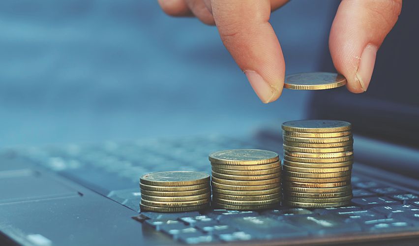 Close-up of a hand counting out coins.